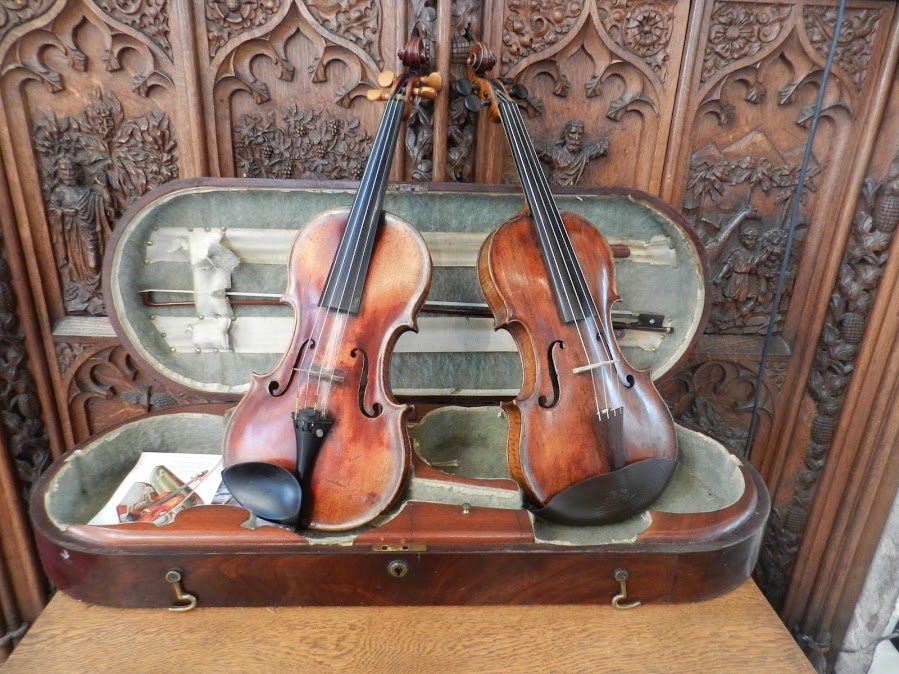 Two Banks violins displayed in an antique case